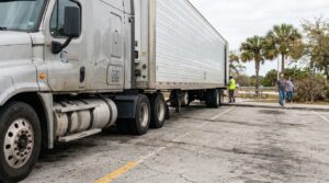 large semi-truck with trailer parked at rest stop near pedestrians